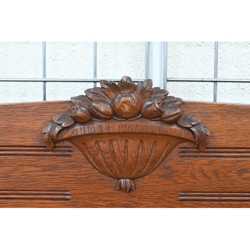 253 - A Dutch oak hall bench settle, of panelled box seated construction carved with baskets of tulips, 13... 