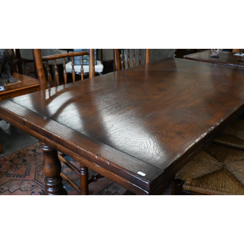 255 - An oak draw-leaf refectory dining table with cleated planked top on turned supports with stretchers,... 