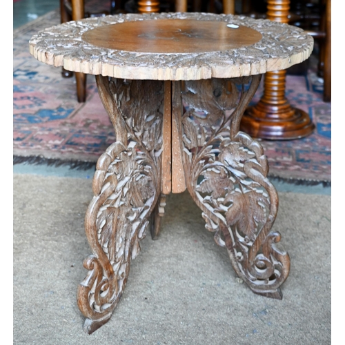 259 - # An Indian carved hardwood occasional table with floral brass inlaid top and folding base, 45 cm di... 