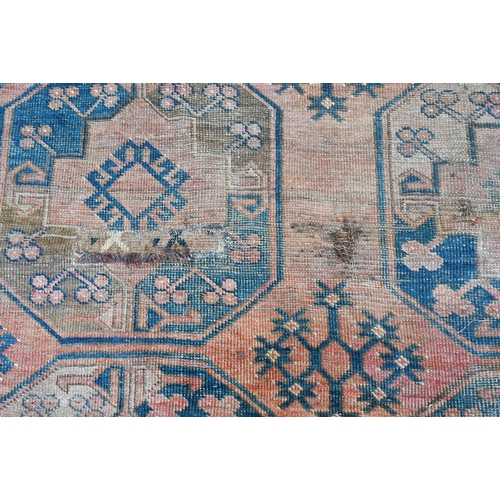 260 - A worn Afghan carpet, with rows of large octagonal guls on red ground, with geometric border, 320 x ... 