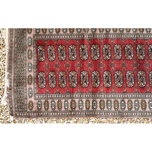 287 - A Parkistani made Turkoman design runner, the teke-gul design on red ground, 320 x 83 cm damage to o... 