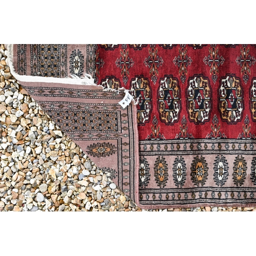 287 - A Parkistani made Turkoman design runner, the teke-gul design on red ground, 320 x 83 cm damage to o... 