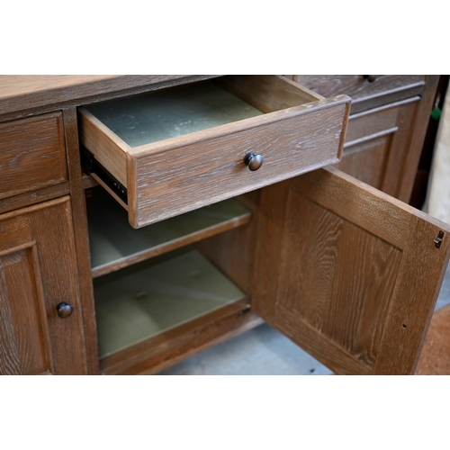 293 - A Multiyork limed oak sideboard with three drawers over panelled cupboards, on tapering square suppo... 