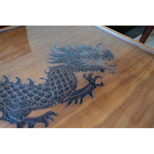 296 - A Chinese hardwood coffee table, the top with copper filigree inset dragon under glass, on shaped su... 