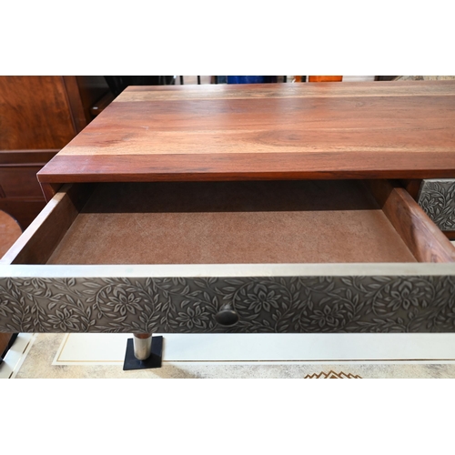 297 - A tropical hardwood coffee table, with four drawers covered with foliate embossed white sheet metal ... 