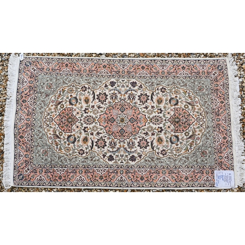 380 - An Indian Kashmir part-silk kashan design rug, of traditional floral design on cream ground, and ora... 