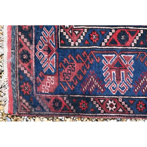 383 - A Turkish Dosemealti red ground rug of geometric design, blue multi borders, 208 x 130 cm