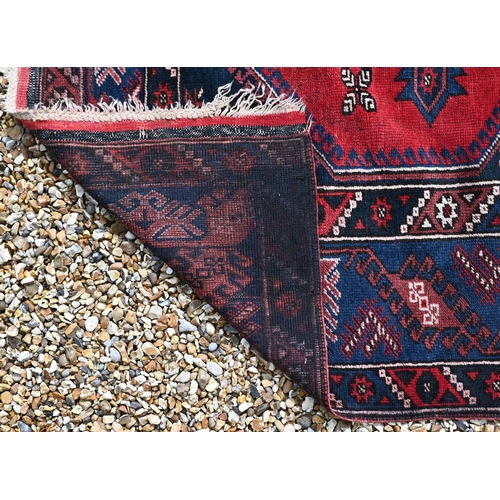 383 - A Turkish Dosemealti red ground rug of geometric design, blue multi borders, 208 x 130 cm