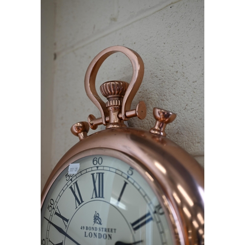 484 - A novelty wall clock in the form of an outsize pocket watch with battery movement