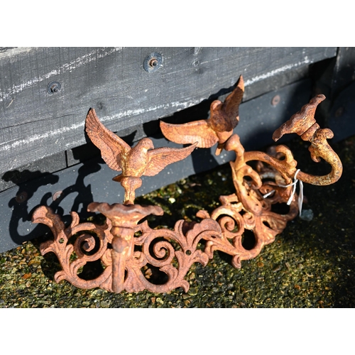 67 - A pair of weathered cast iron single arm wall sconces surmounted by a bird (2)