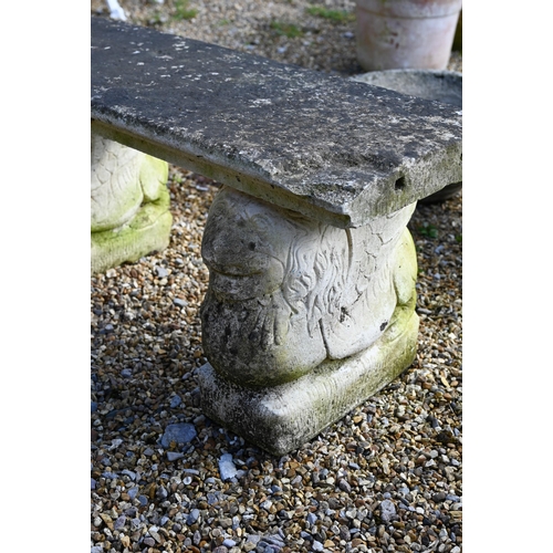 68 - A small weathered three piece cast stone garden bench, with lion form bases