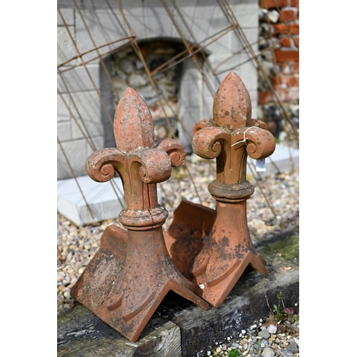 87 - A close pair of old weathered fleur-de-lys finial terracotta ridge tiles, a/f (2)