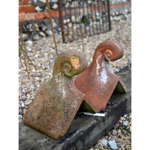 89 - Two weathered old terracotta scroll finial ridge tiles, a/f (2) 