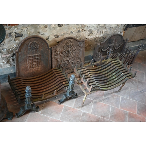 97 - Two old cast iron fire backs to/with three fire baskets, a large cast iron trivet and a pair of fire... 