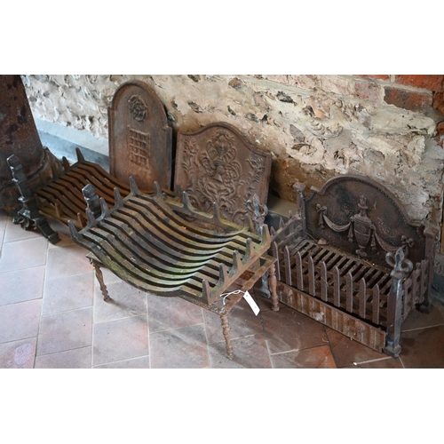 97 - Two old cast iron fire backs to/with three fire baskets, a large cast iron trivet and a pair of fire... 