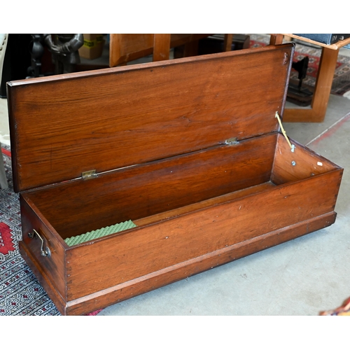 286 - An antique low hardwood brass handled trunk on casters, 112 cm wide x 37 cm deep x 30 cm high