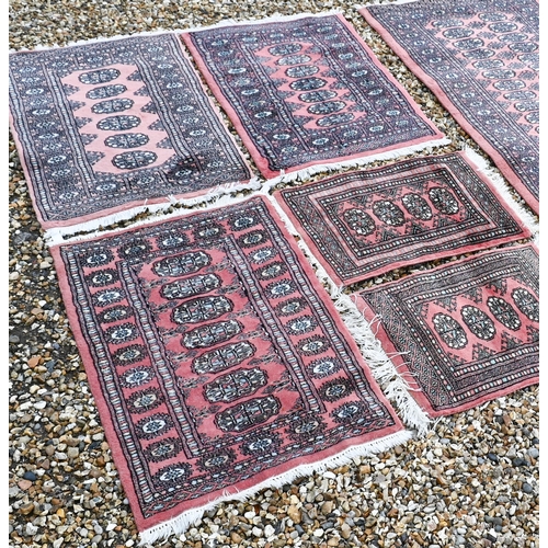 376 - Five various Pakistani Turkoman design rugs, all with repeating gul design on terracotta ground (5)