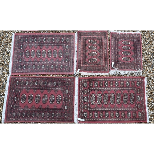 376 - Five various Pakistani Turkoman design rugs, all with repeating gul design on terracotta ground (5)