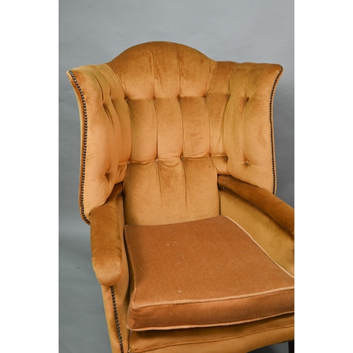 634 - An antique button and wing backed armchair raised on square tapering front legs to ceramic casters, ... 