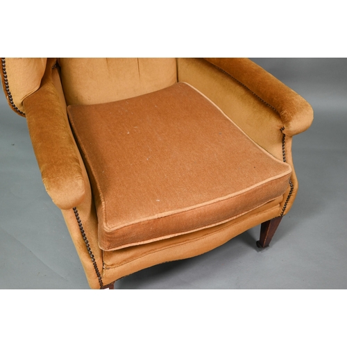 634 - An antique button and wing backed armchair raised on square tapering front legs to ceramic casters, ... 