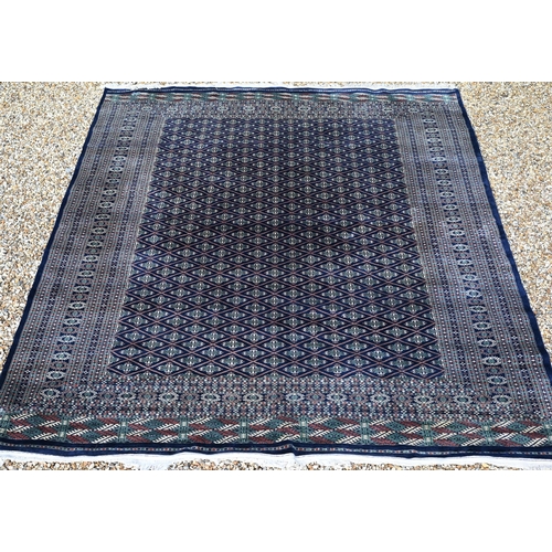 225 - A large Pakistani Turkoman design carpet, the blue ground with repeating gul design and multi-border... 