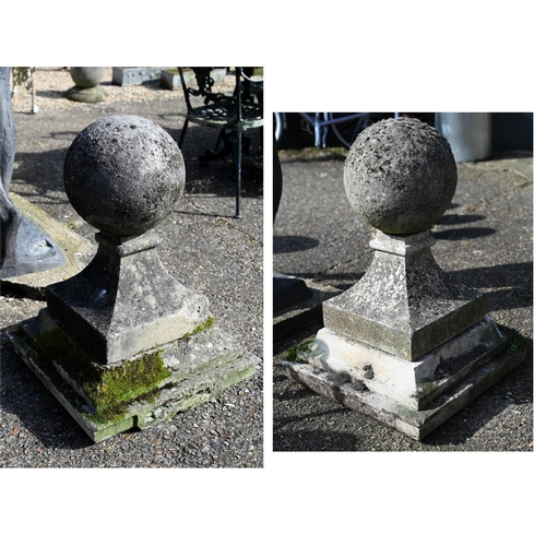A large pair of antique weathered cast stone ball finial pier caps, raised on tapering form square bases, each 70 cm h o/all (2)