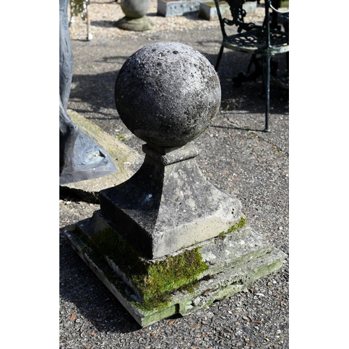 1 - A large pair of antique weathered cast stone ball finial pier caps, raised on tapering form square b... 