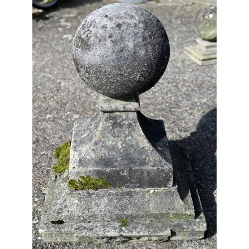 1 - A large pair of antique weathered cast stone ball finial pier caps, raised on tapering form square b... 