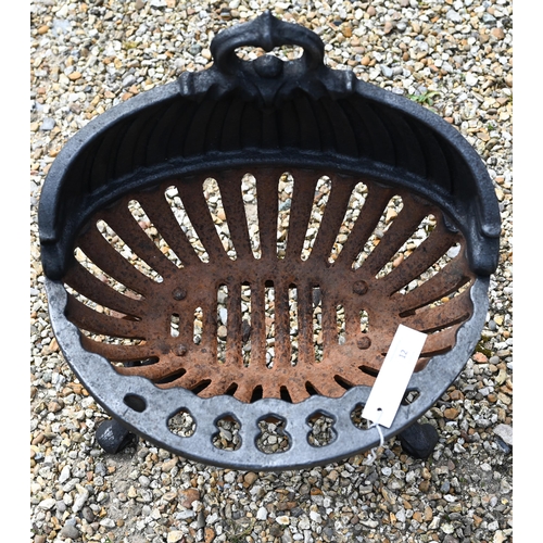 12 - An old oval cast iron fire basket, raised on scroll feet, 40 cm w