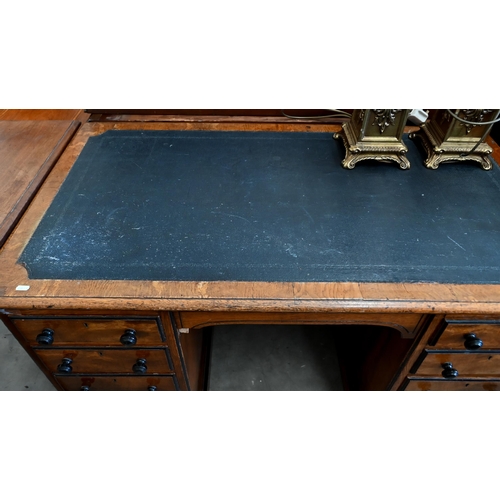 140 - A late Victorian Aesthetic movement oak eight drawer desk with turned ebony handles and inset leathe... 