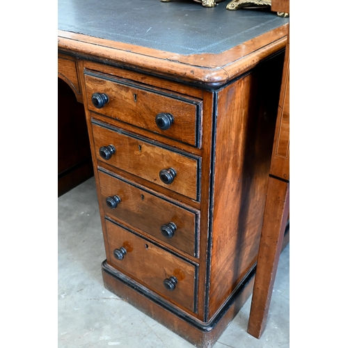 140 - A late Victorian Aesthetic movement oak eight drawer desk with turned ebony handles and inset leathe... 