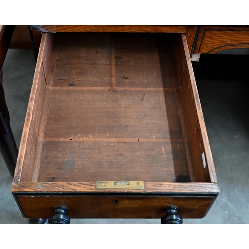 140 - A late Victorian Aesthetic movement oak eight drawer desk with turned ebony handles and inset leathe... 