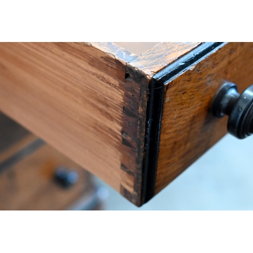 140 - A late Victorian Aesthetic movement oak eight drawer desk with turned ebony handles and inset leathe... 