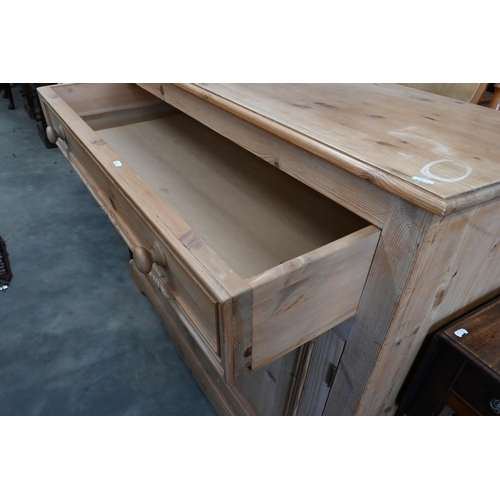 147 - A pine side cabinet/dresser base with single drawer over panelled cupboard doors, 124 x 54 x 94 cm h... 