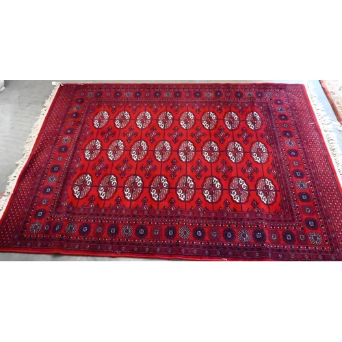 149 - A Turkoman design rug with repeat gul design on red ground 190 x 124 cm to/w similar machine made ex... 