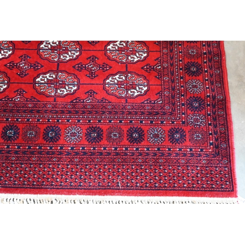 149 - A Turkoman design rug with repeat gul design on red ground 190 x 124 cm to/w similar machine made ex... 