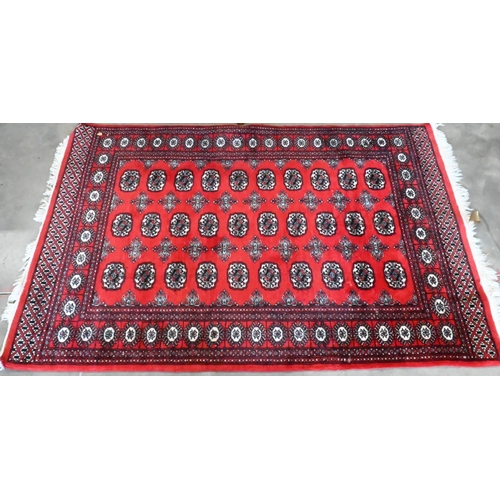 149 - A Turkoman design rug with repeat gul design on red ground 190 x 124 cm to/w similar machine made ex... 