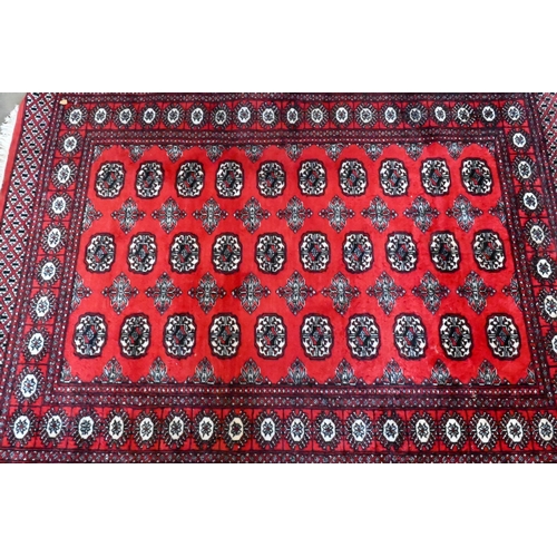 149 - A Turkoman design rug with repeat gul design on red ground 190 x 124 cm to/w similar machine made ex... 