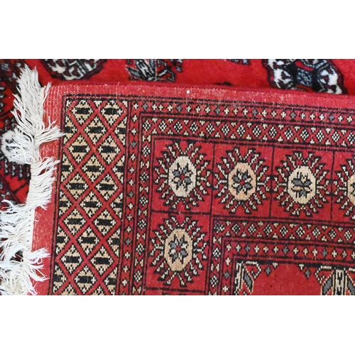 149 - A Turkoman design rug with repeat gul design on red ground 190 x 124 cm to/w similar machine made ex... 