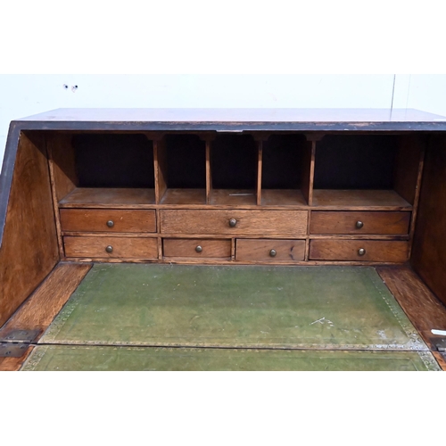 152 - #A small oak fall front bureau with four graduating drawers and shaped bracket feet, 70 cm wide x 44... 