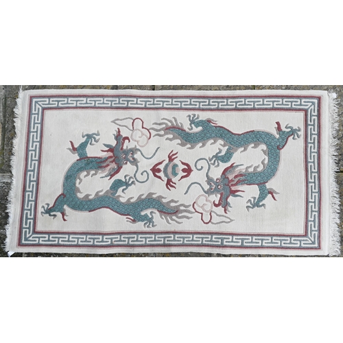 167 - #A modern Chinese cut wool pictorial rug with two dragons disputing a flaming pearl on cream ground,... 