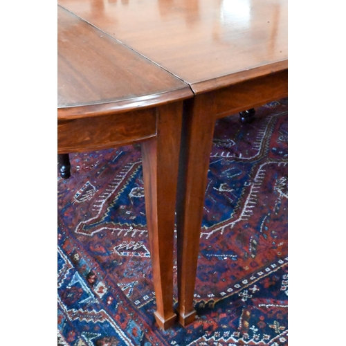 170 - A large hardwood dining table on square supports with spade feet and central rectangular section, 21... 