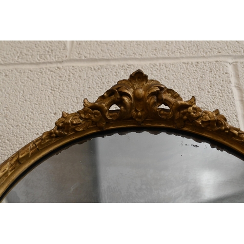 180 - An antique circular wall mirror in giltwood and gesso decorative frame, 50 x 42 cm