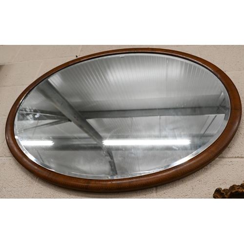 185 - An Edwardian bevelled oval mirror in inlaid walnut frame, 103 cm wide x 78 cm high