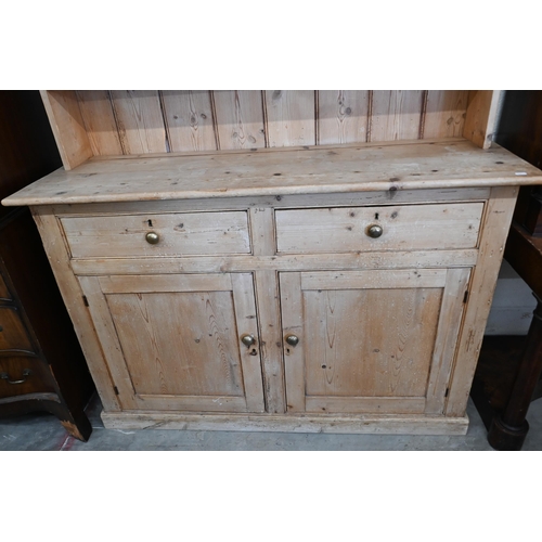 188 - An antique stripped pine kitchen dresser with plate rack over two drawers and panelled cupboards, 13... 