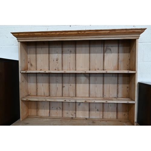 188 - An antique stripped pine kitchen dresser with plate rack over two drawers and panelled cupboards, 13... 