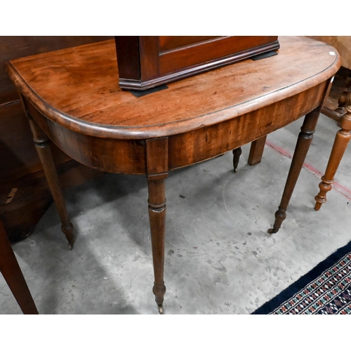 213 - A 19th century mahogany demi lune console table on turned supports and brass castors 88 x 52 x 70 cm... 