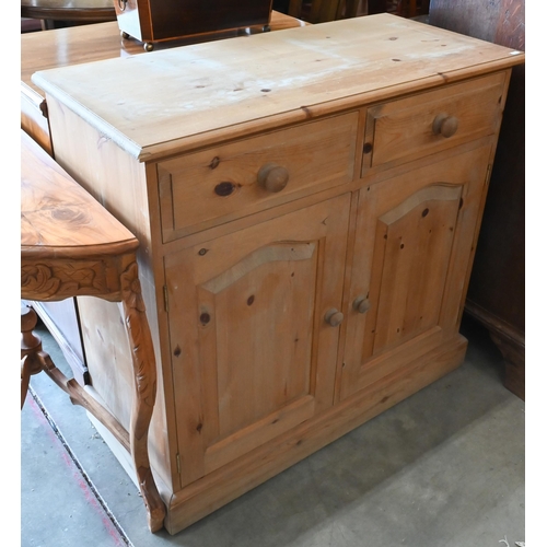 231 - A waxed pine side cabinet with two drawers over panelled cupboards, 92 x 42 x 86 cm high