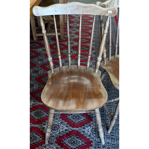 234 - A set of four provincial elm and beech spindle back dining chairs