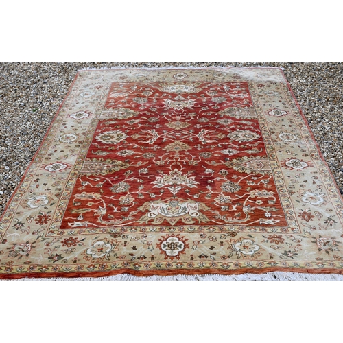 240 - An Indian Agra carpet, traditional floral design on terracotta field, beige rosette border, 274 cm x... 